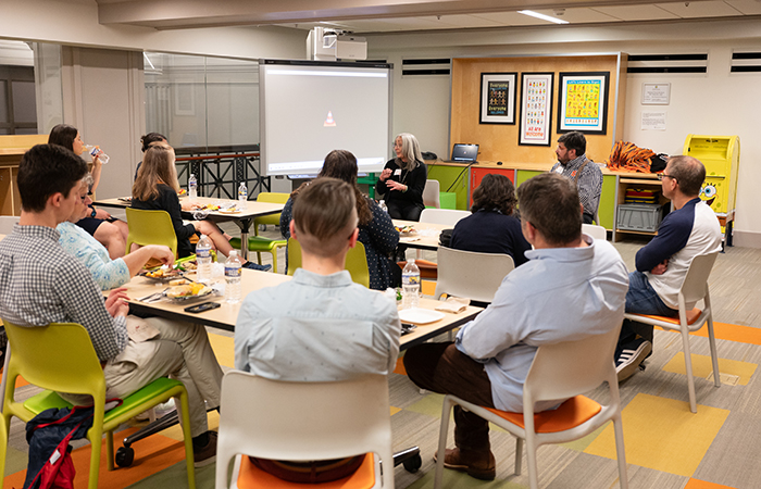 Guests listen to Tere Paniagua '82 and Daniel Piazza G’04 discuss the development of the exhibit.